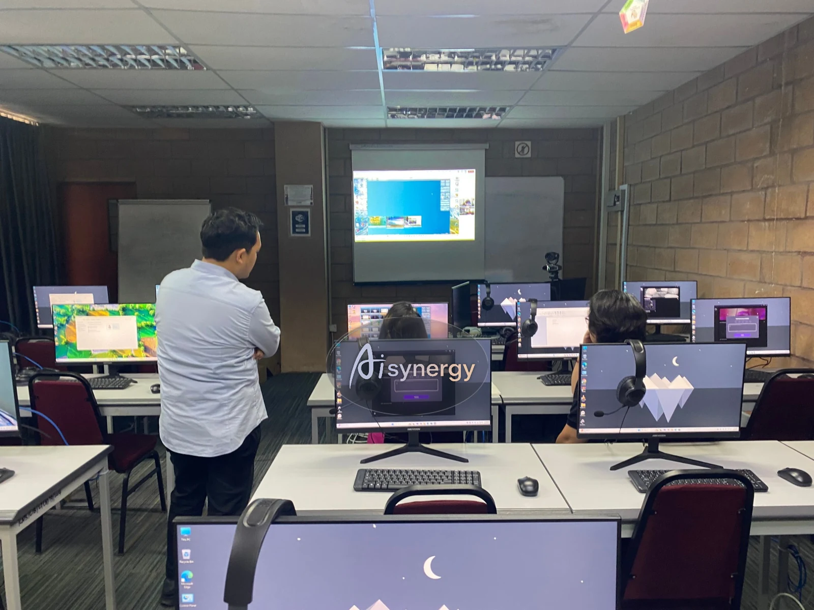 Trainer reviewing participants’ screens during a hands-on computer-lab session